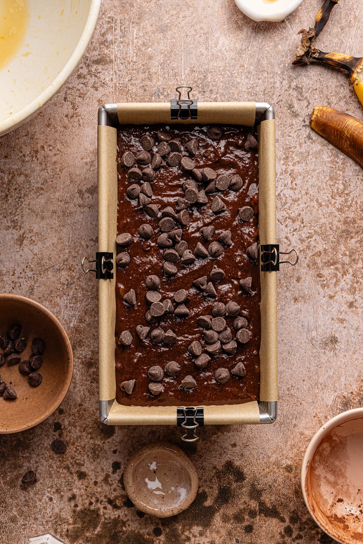 The chocolate bread batter in a bread pan lined with parchment paper.
