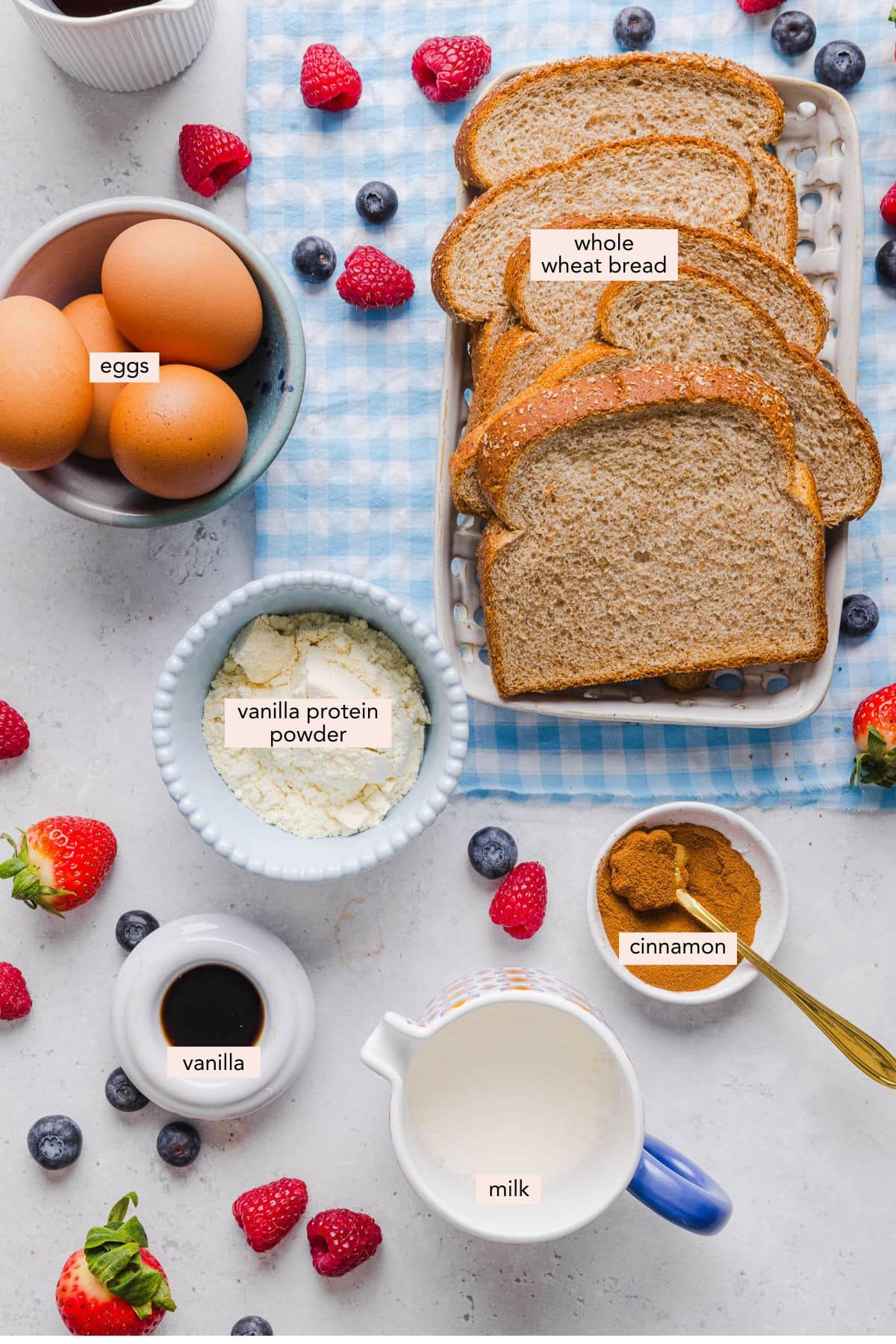 All of the ingredients for high protein french toast in bowls on a white countertop.