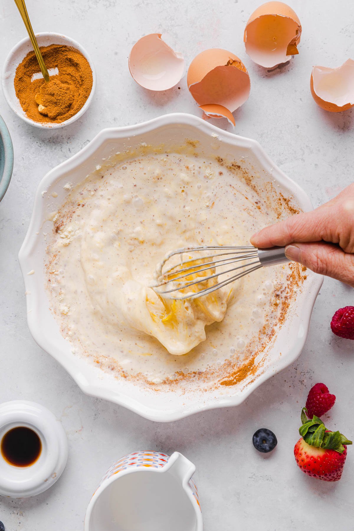 Whisking together the batter for the french toast in a shallow baking dish.