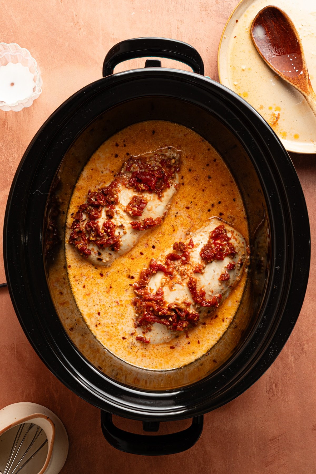 The cooked chicken in the slow cooker with the cream sauce.