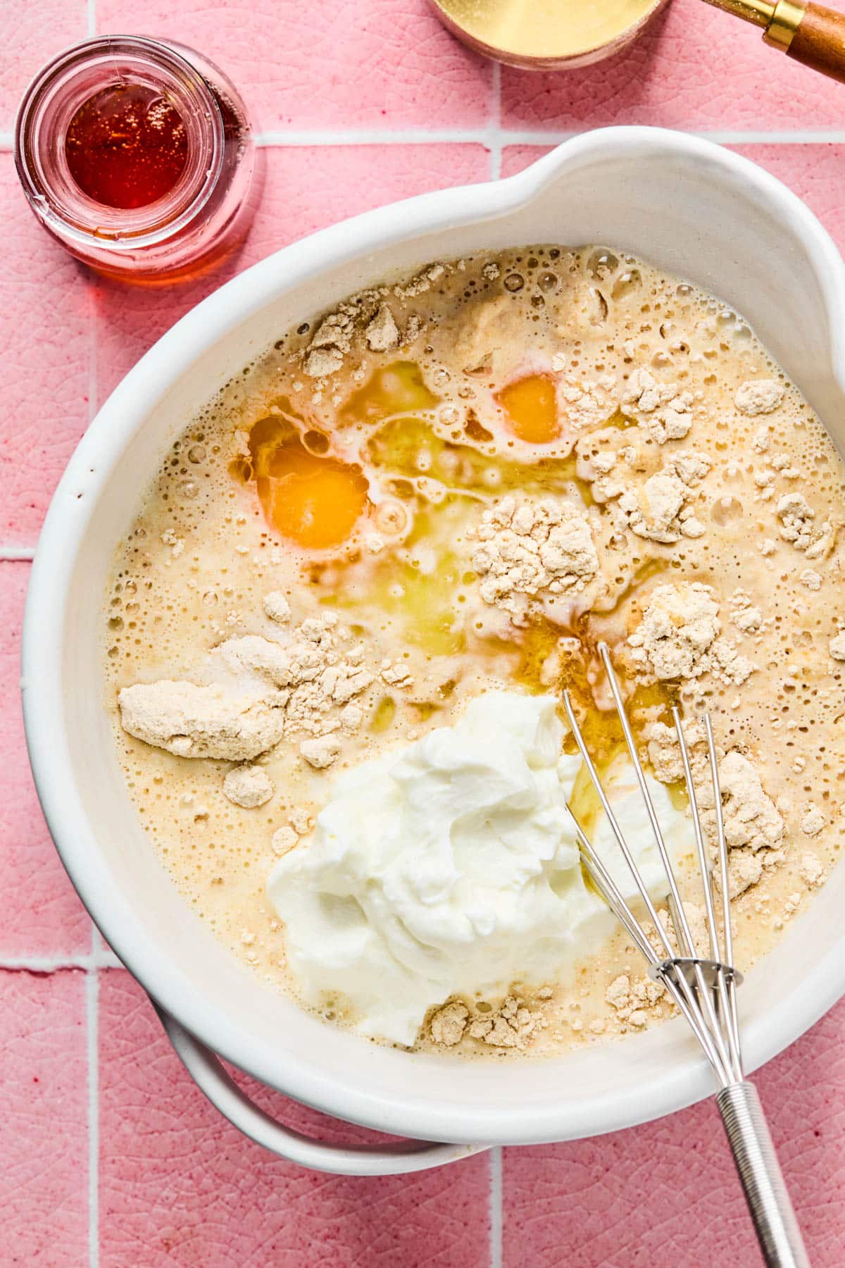 The pancake mix, greek yogurt, milk, eggs, oil, maple syrup, vanilla, and salt in a bowl before mixing.