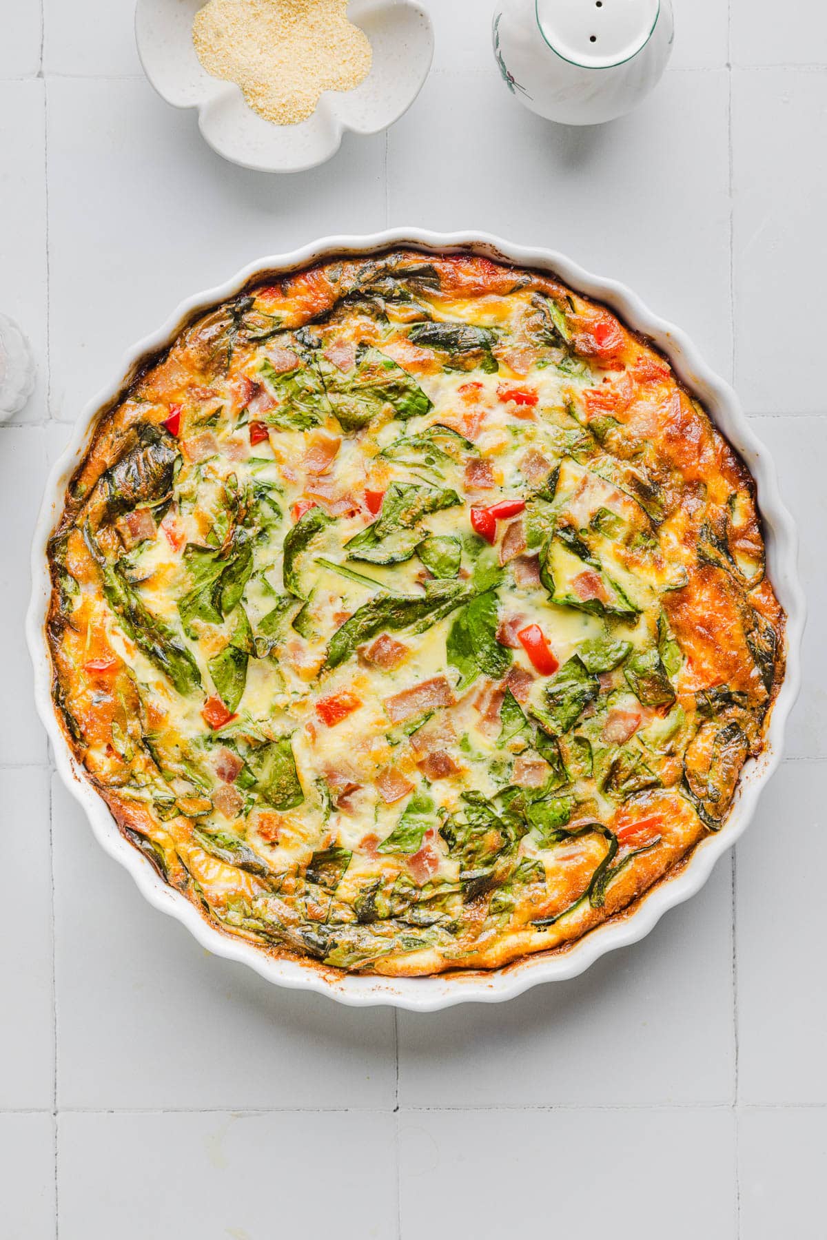 The baked quiche in a baking dish on a white countertop.