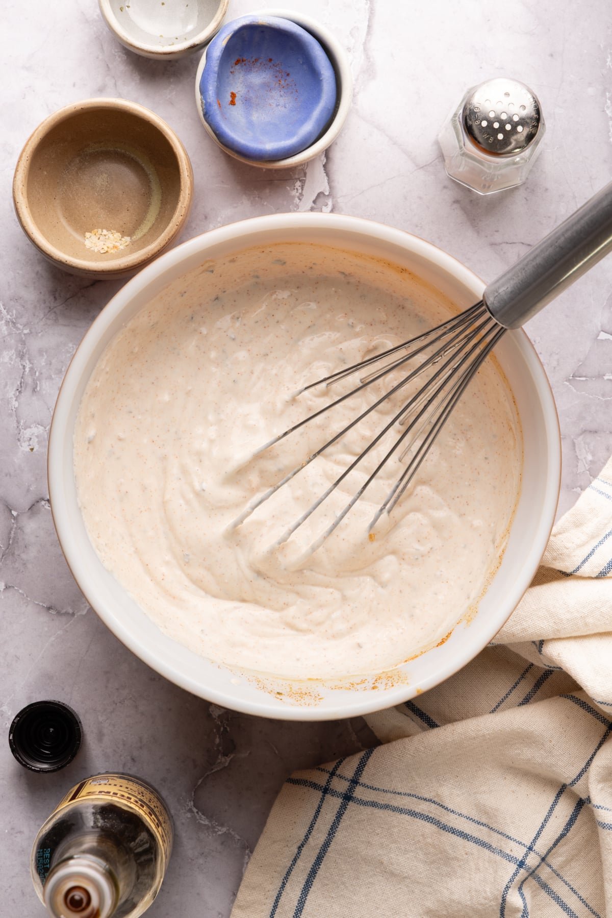 The dip whisked together in a white bowl with the whisk still sitting in the bowl.