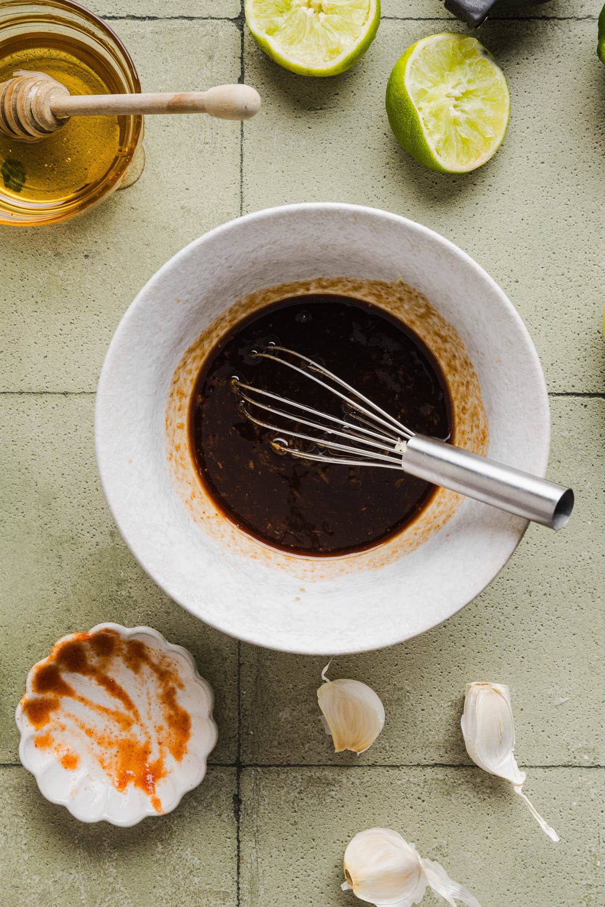 All of the ingredients for the honey sriracha sauce in bowls on a countertop.