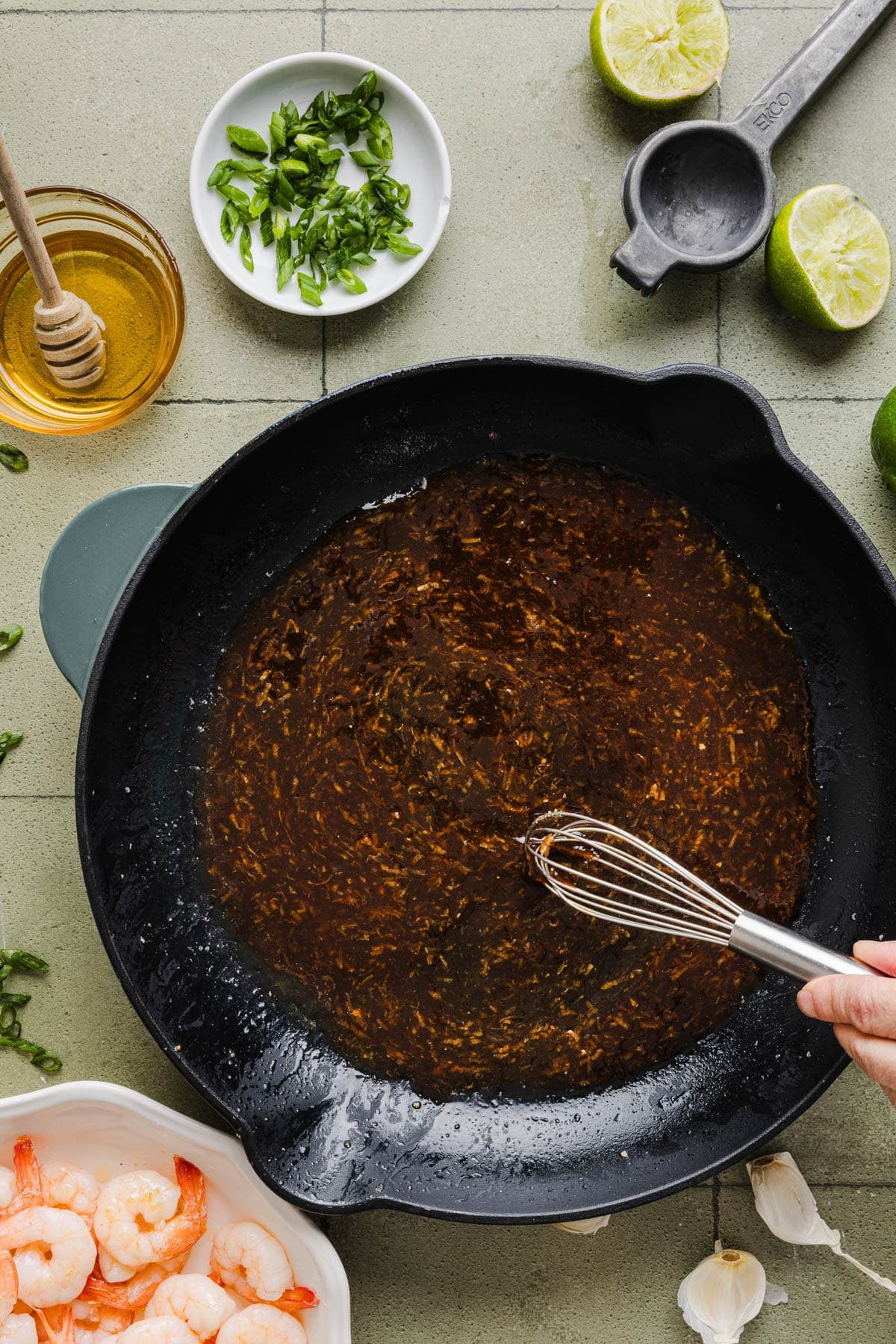 A whisk stirs the sauce in the pan.
