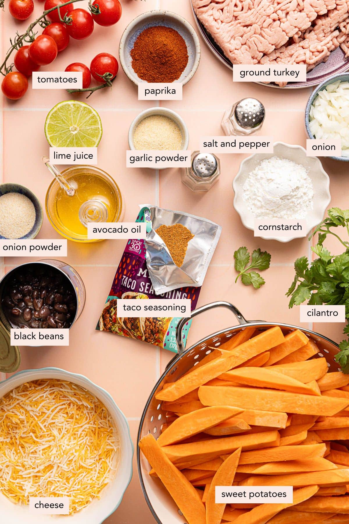 All of the ingredients for loaded sweet potato fries in bowls on a countertop.