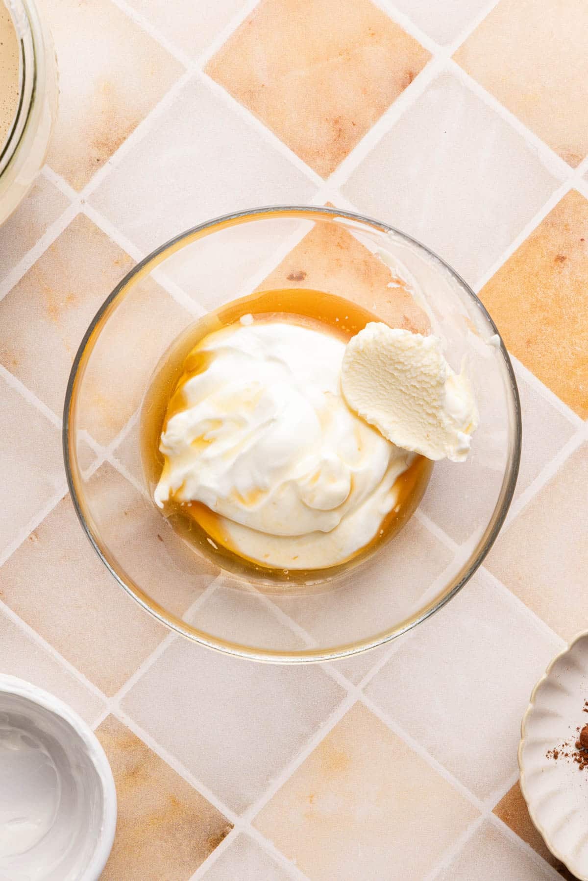 The greek yogurt, mascarpone cheese, maple syrup, and vanilla extract in a bowl before mixing together to make the topping.