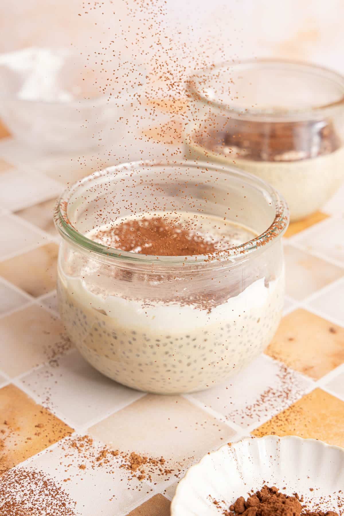 Dusting the cocoa powder on top of the tiramisu chia pudding before serving.