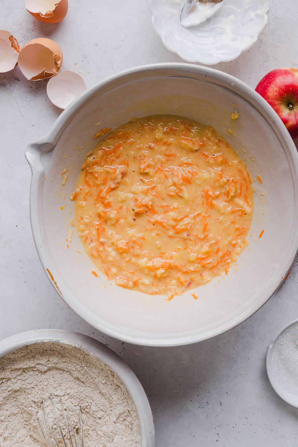 The muffin batter in a bowl after stirring in the carrots, apple, and banana.