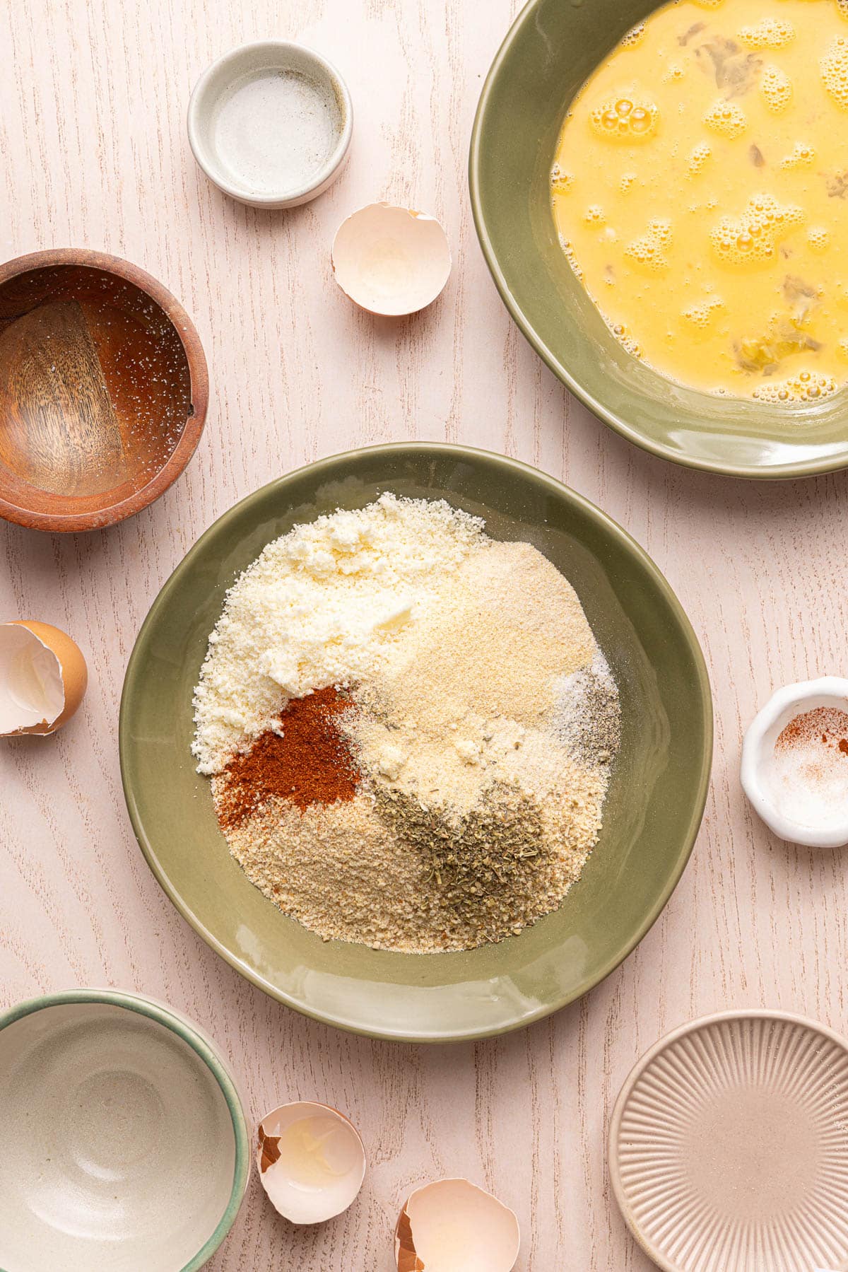 The breadcrumbs, cheese, seasoning, garlic powder, onion powder, paprika, salt, and pepper in a bowl on a countertop.
