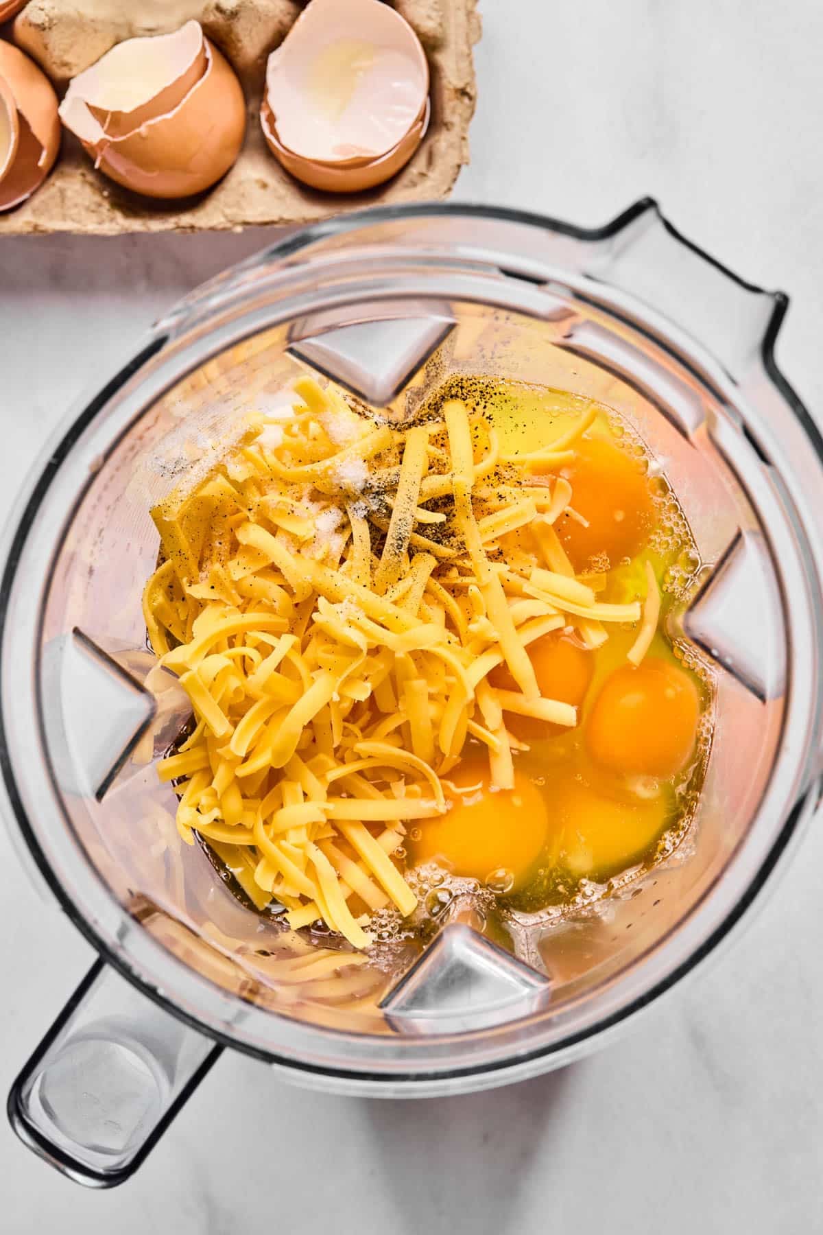 The eggs, cottage cheese, shredded cheddar cheese, salt and pepper in a blender before blending.