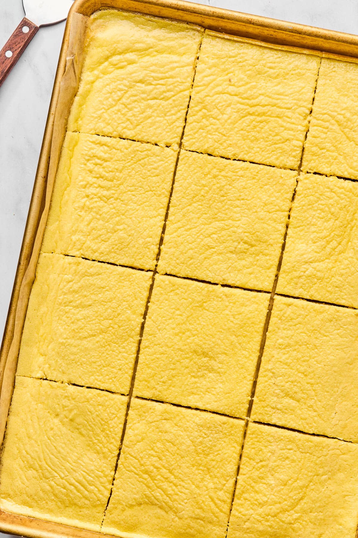 The baked eggs in the baking sheet sliced into 12 squares.