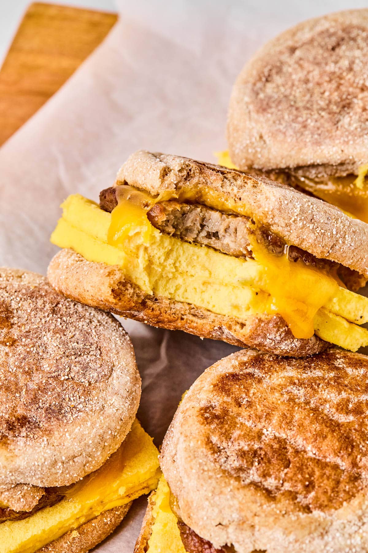 A breakfast sandwich with a bite taken out of it placed with the rest of the sandwiches.
