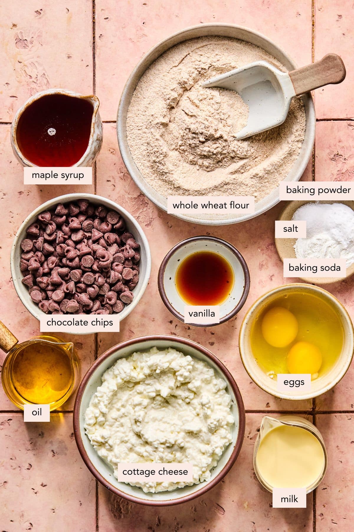 All of the ingredients for cottage cheese chocolate chip muffins in bowls on a countertop.