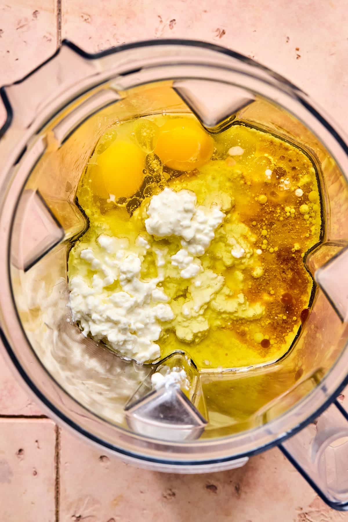 The cottage cheese, milk, oil, maple syrup, eggs, and vanilla in a blender before mixing.