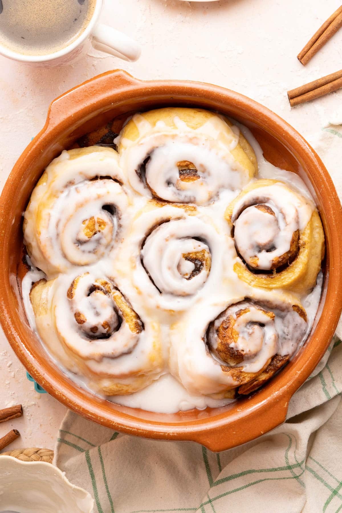 Cottage cheese cinnamon rolls in a baking dish with glaze drizzled on top after baking.