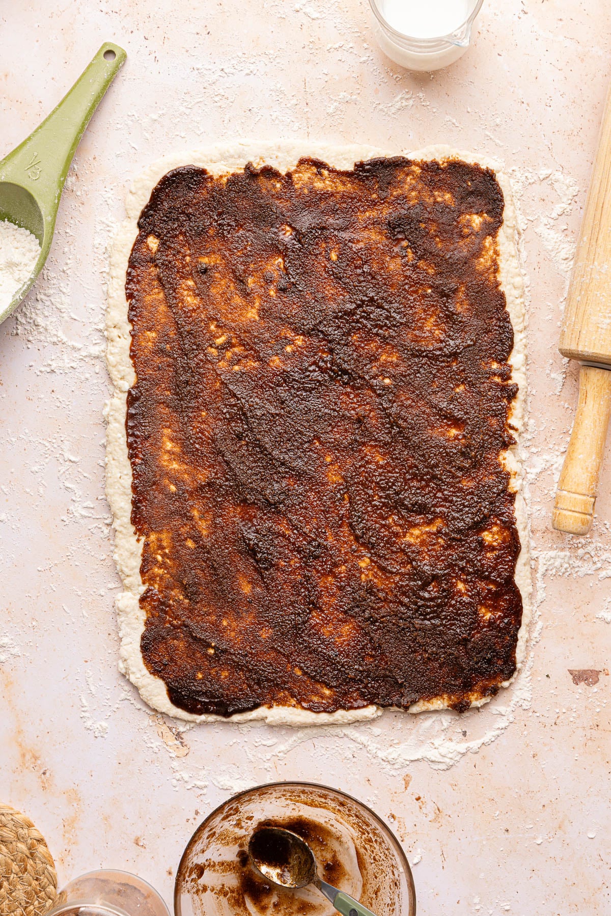 The brown sugar cinnamon mixture spread over the top of the rectangular piece of dough.