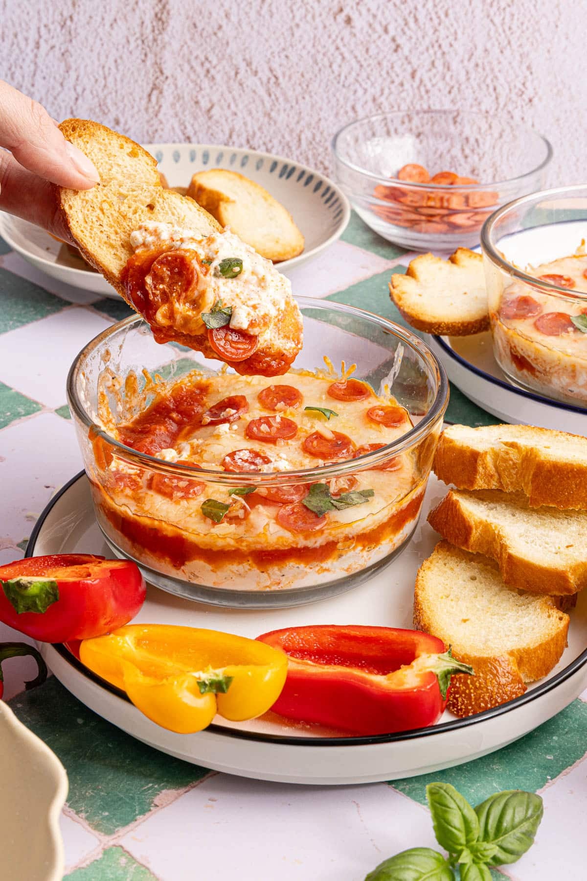 A piece of bread dipping into the cottage cheese pizza dip.