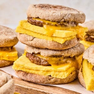Two high protein meal prep breakfast sandwiches sitting on a cutting board ready for serving.