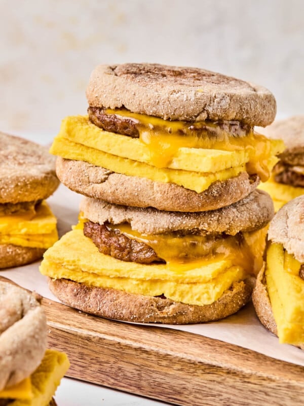 Two high protein meal prep breakfast sandwiches sitting on a cutting board ready for serving.
