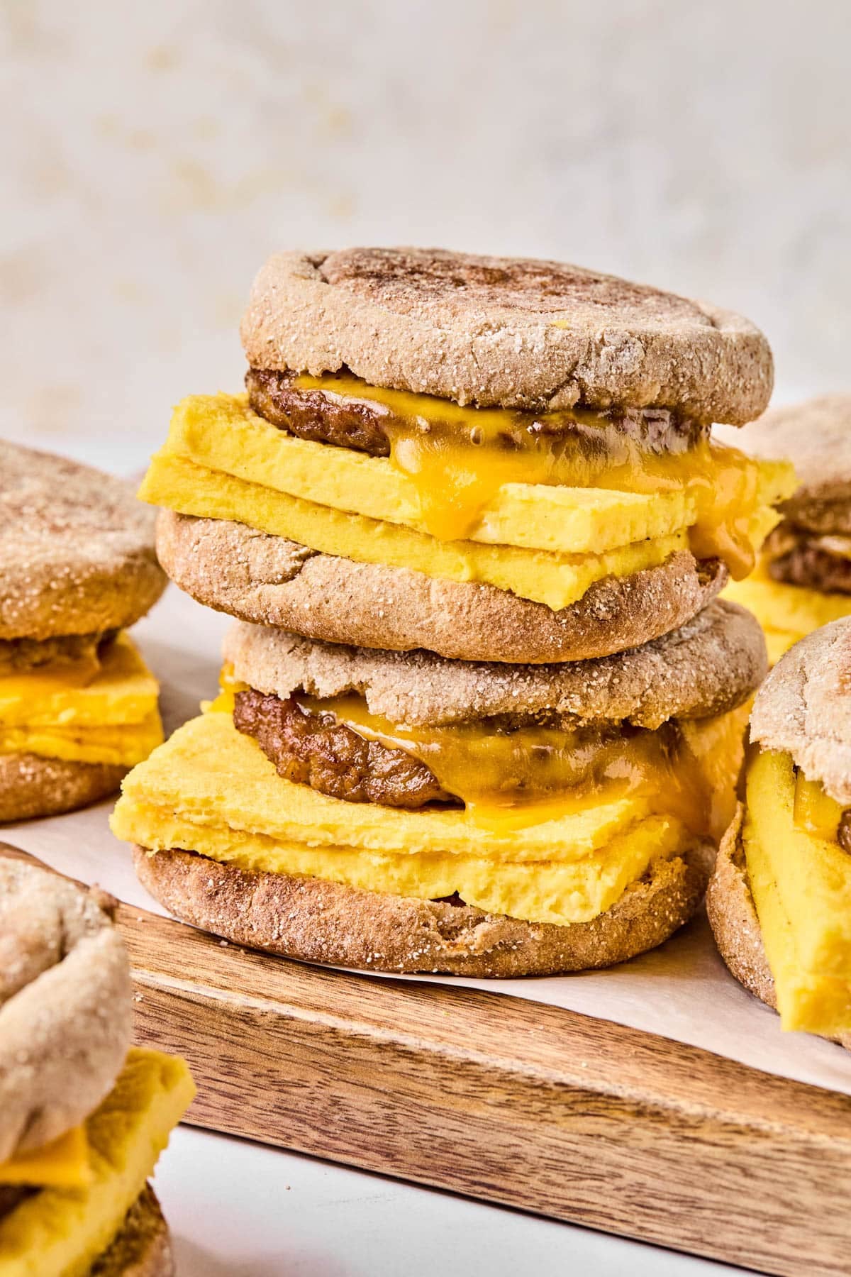 Two high protein meal prep breakfast sandwiches sitting on a cutting board ready for serving.