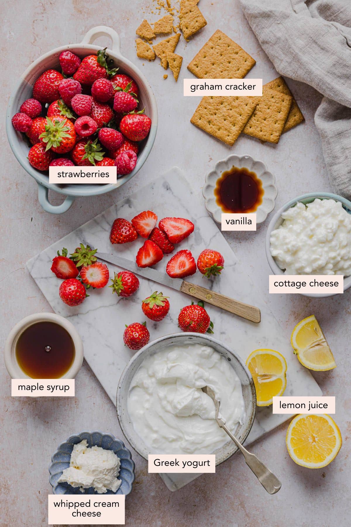 All of the ingredients for high protein cheesecake jars in bowls on a countertop.
