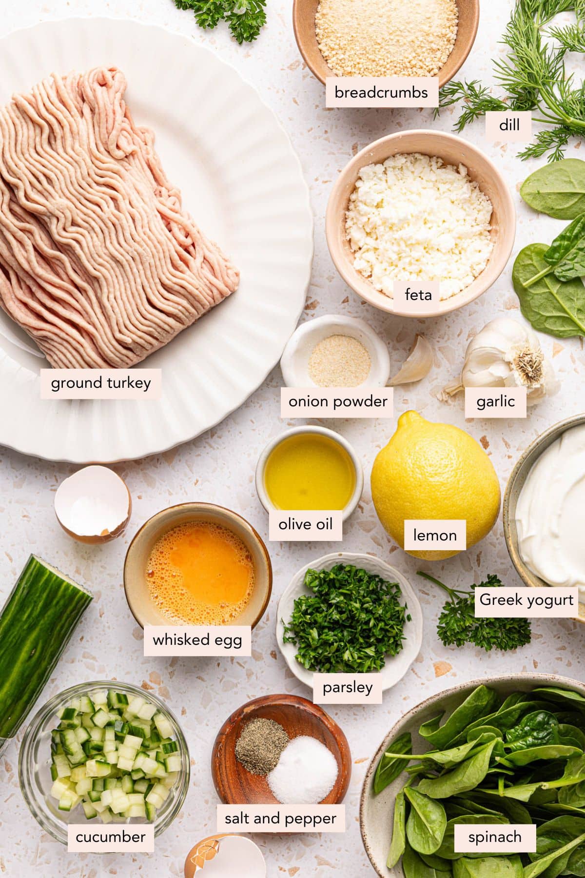 All of the ingredients for turkey and feta meatballs in bowls on a white countertop.