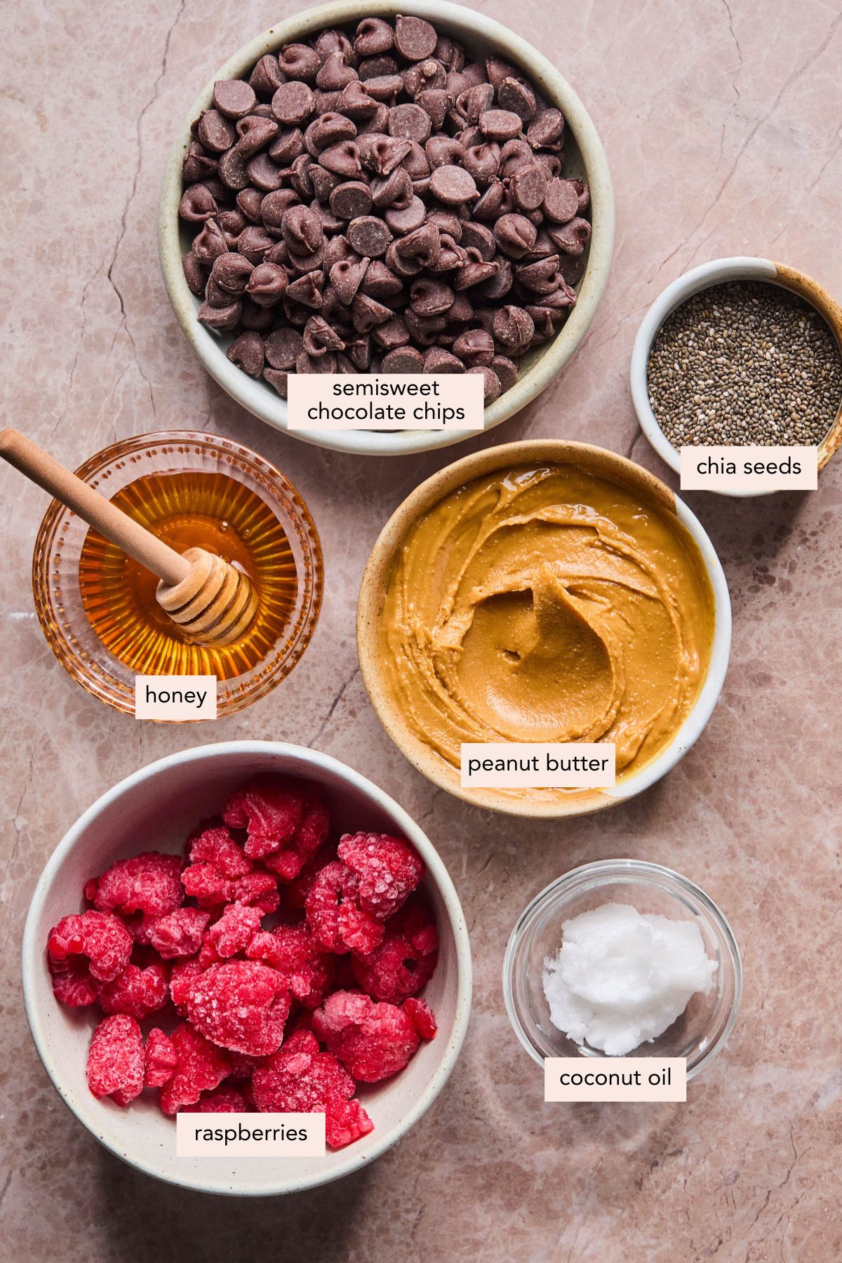All of the ingredients for peanut butter and jelly cups in bowls on a countertop.