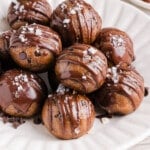 Banana protein balls sitting in a pile on a white plate.
