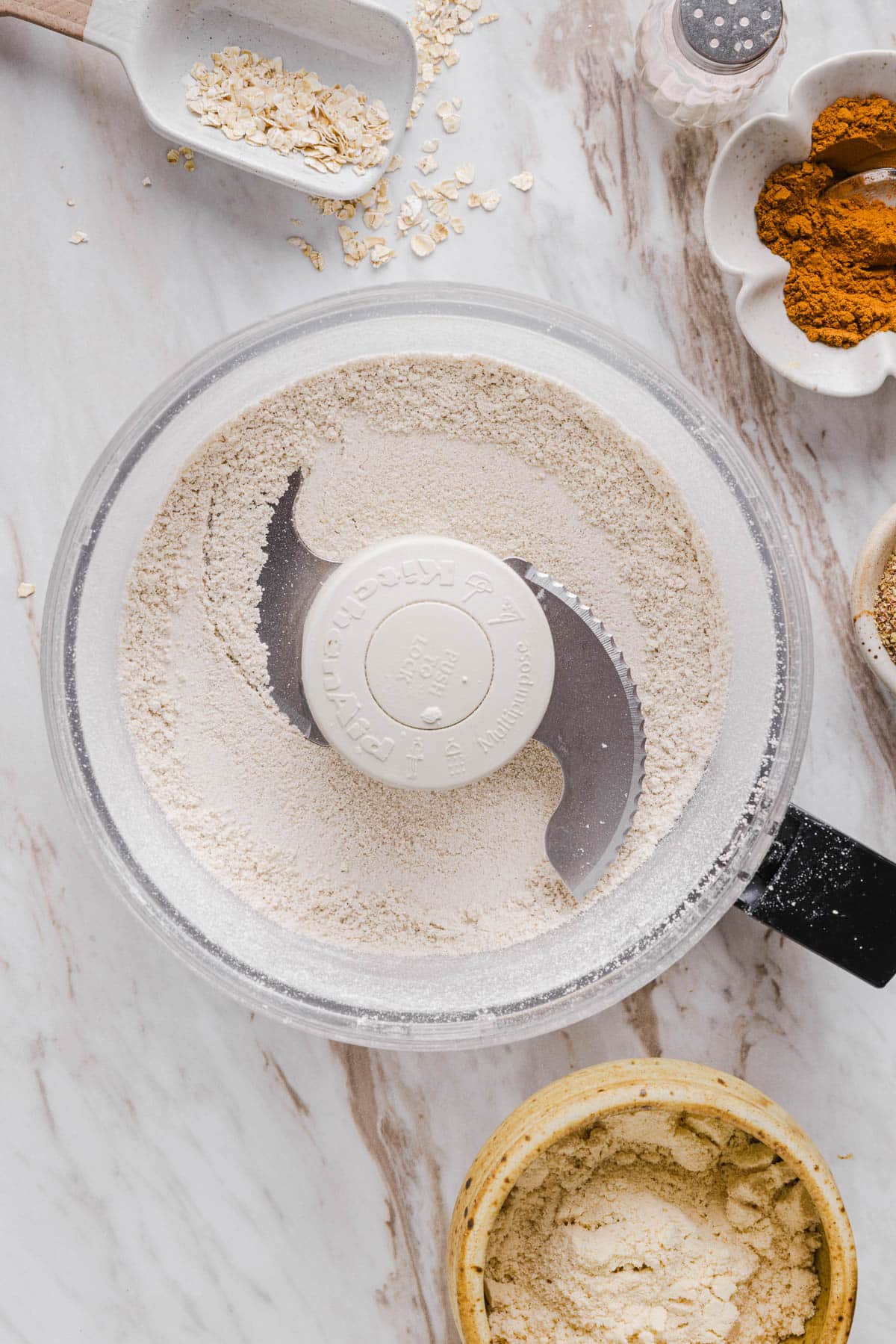 The oats processed into a very fine flour in a food processor bowl.