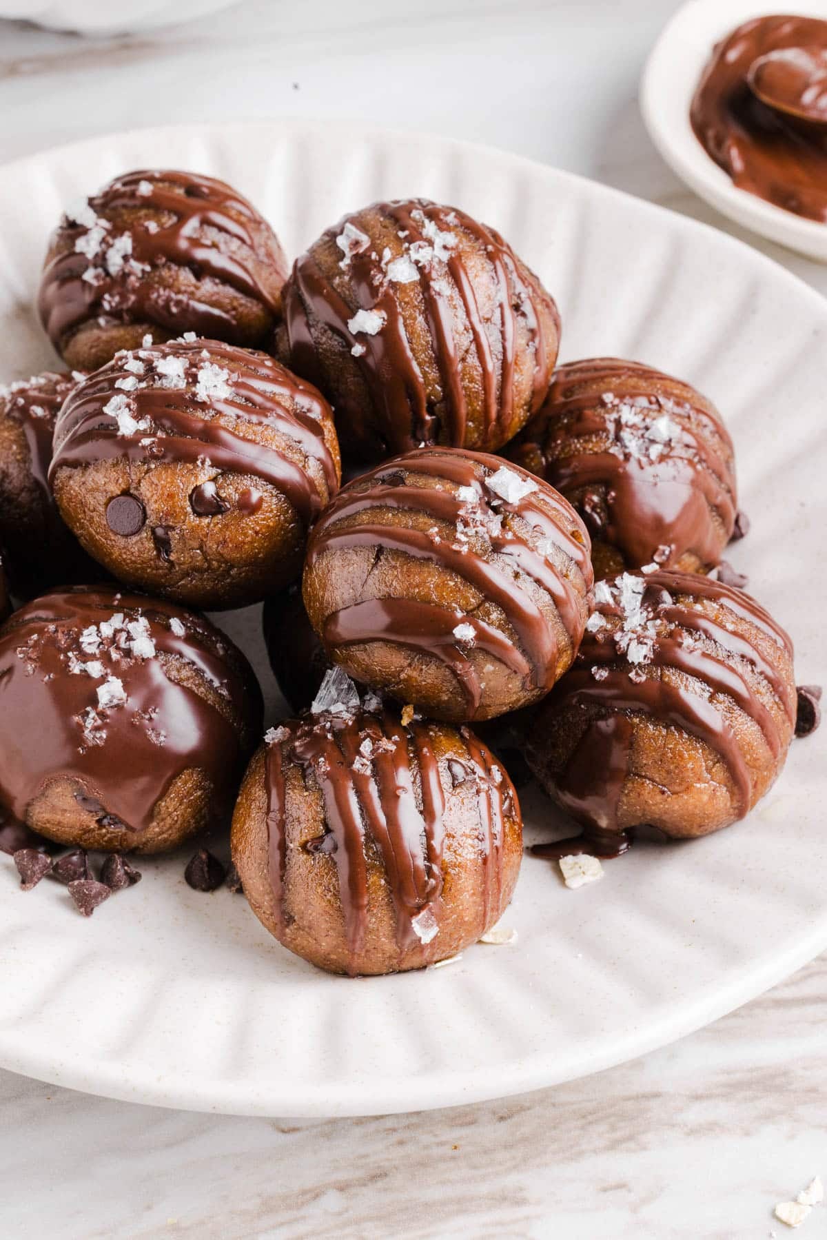 Banana protein balls sitting in a pile on a white plate.