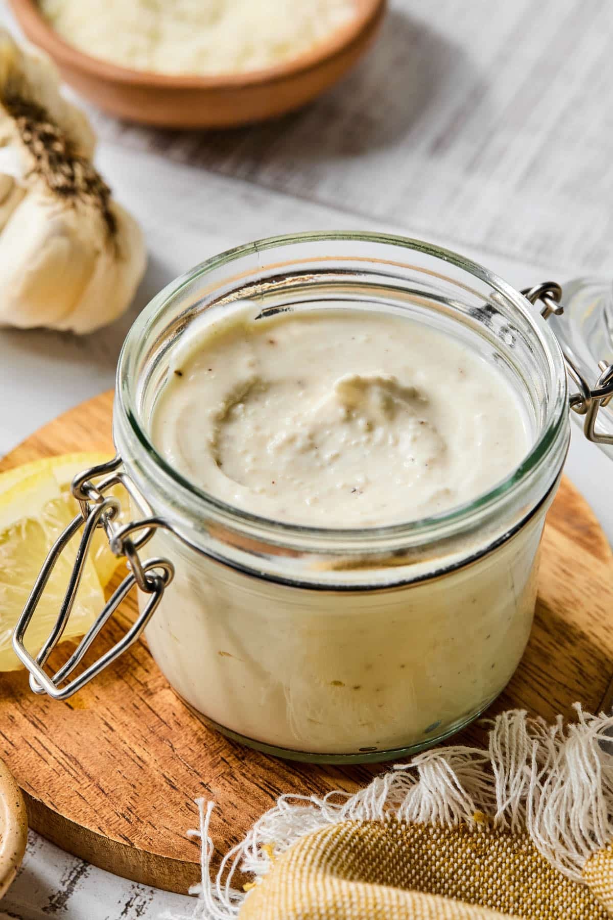 A glass jar filled with greek yogurt caesar salad dressing.