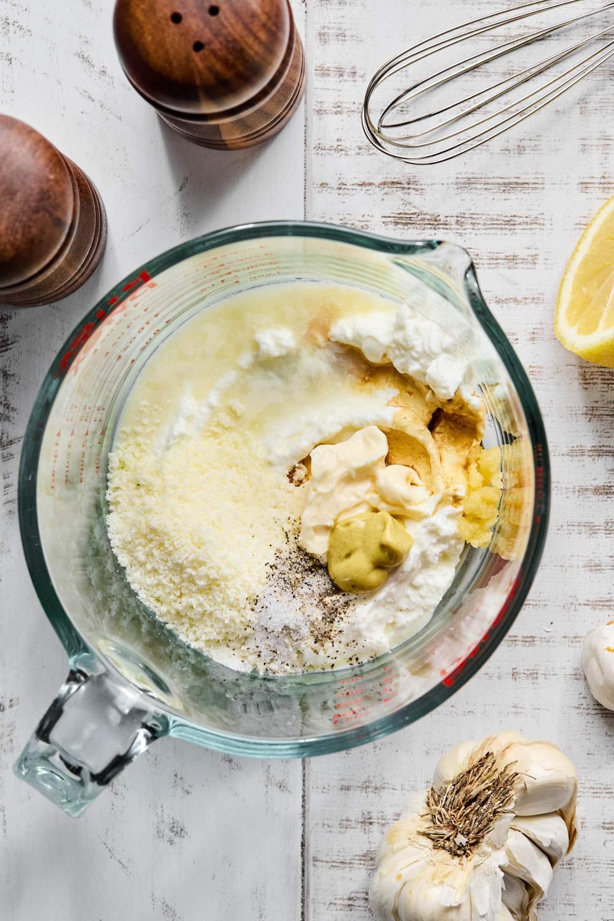 All of the ingredients for greek yogurt caesar dressing in a glass mixing bowl before mixing.