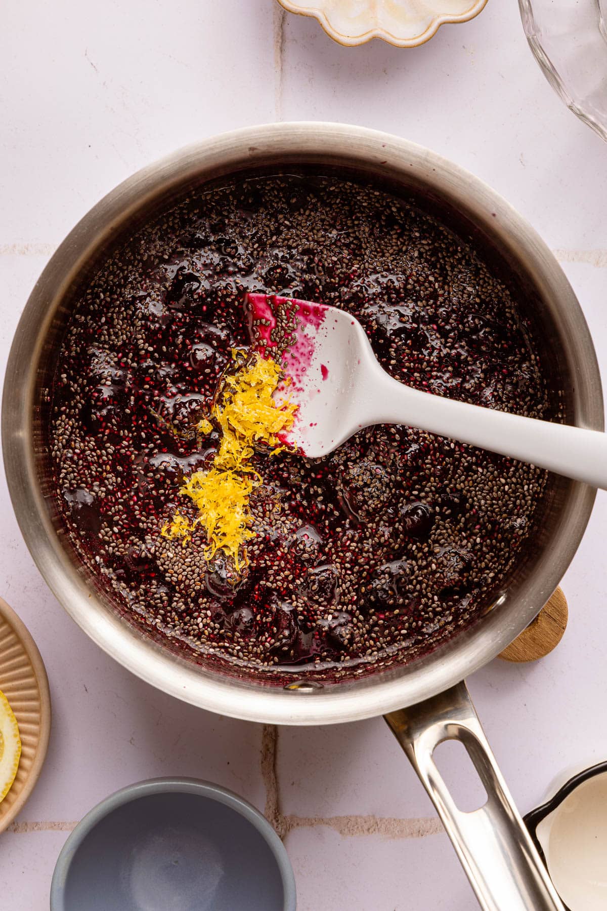 The lemon zest and chia seeds in the pot with the mashed berries.