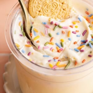 Ninja creami cake batter ice cream in a container with a spoon and oreo cookie in it.