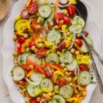 No lettuce salad in a serving bowl with serving utensils.