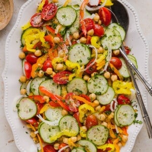 No lettuce salad in a serving bowl with serving utensils.