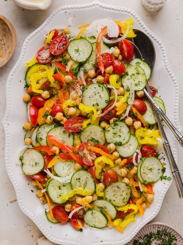No lettuce salad in a serving bowl with serving utensils.