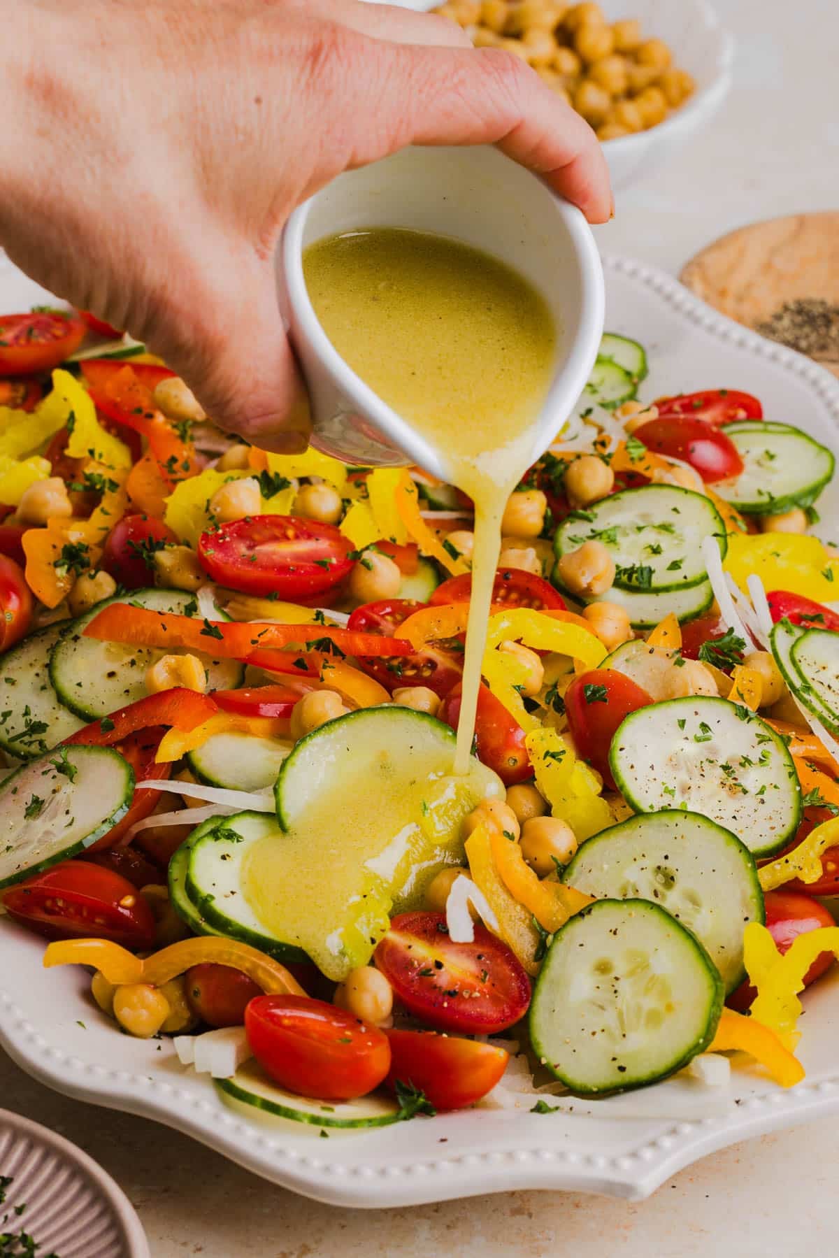 Pouring the dressing over the salad ingredients.