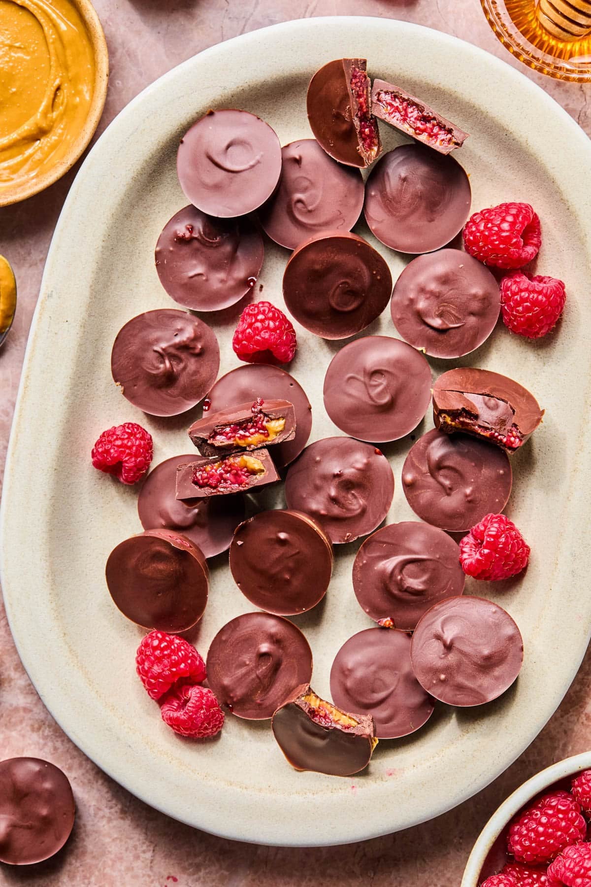 The chilled cups on a platter for serving with fresh raspberries garnished on the side.