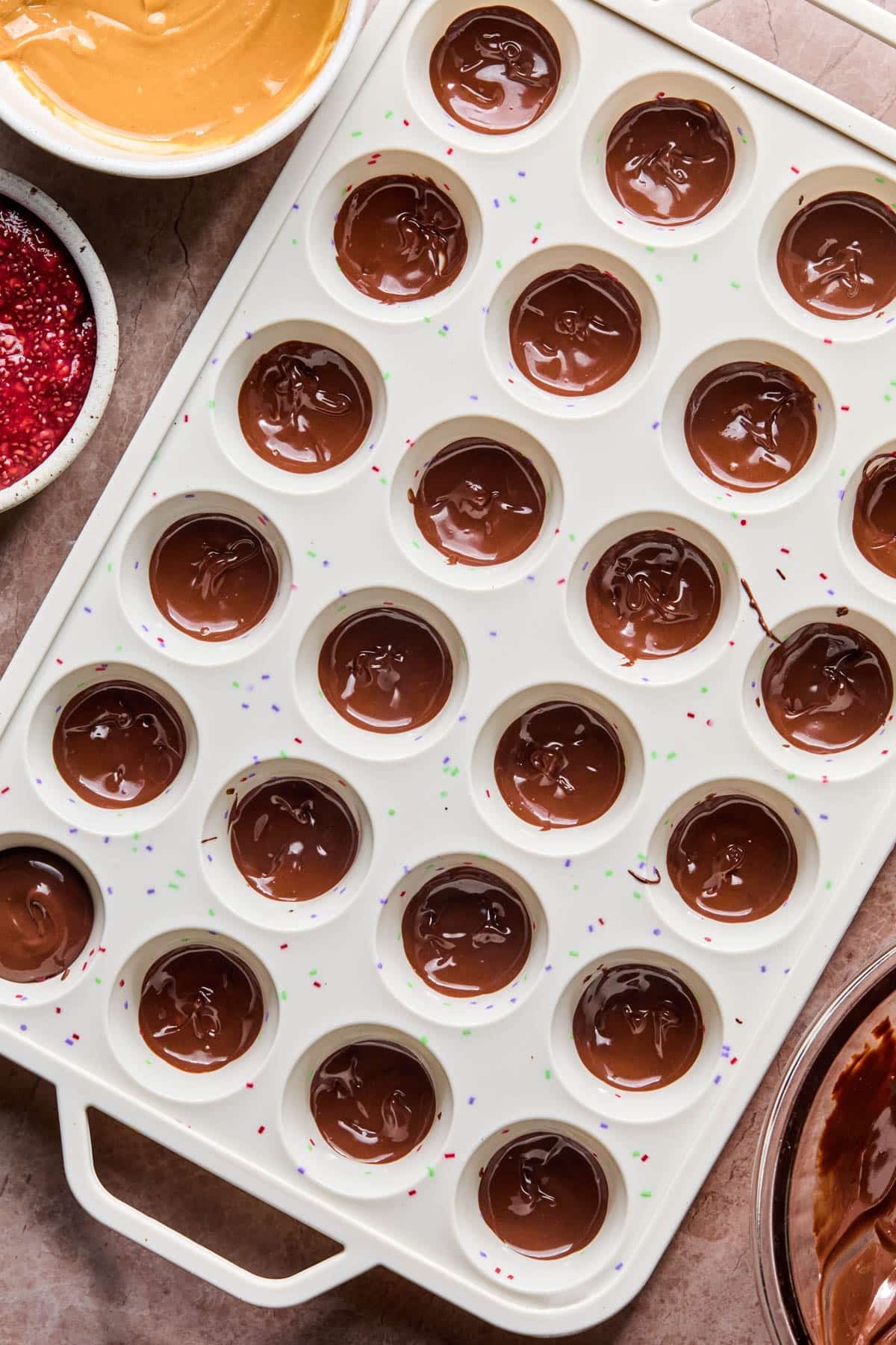 The melted chocolate in the silicone baking cups before adding the peanut butter.