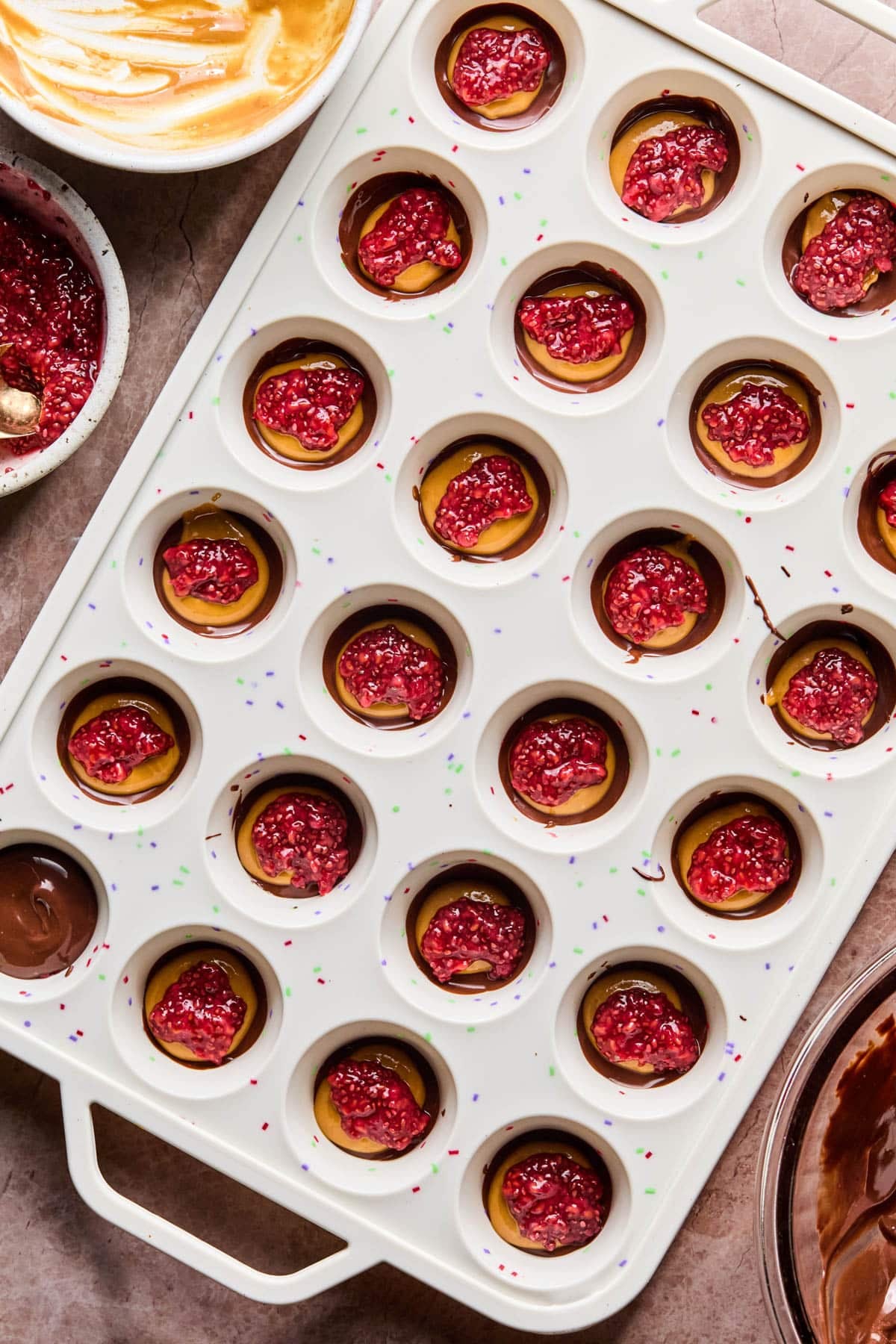 The raspberry chia jam on top of the peanut butter and chocolate in the cups.