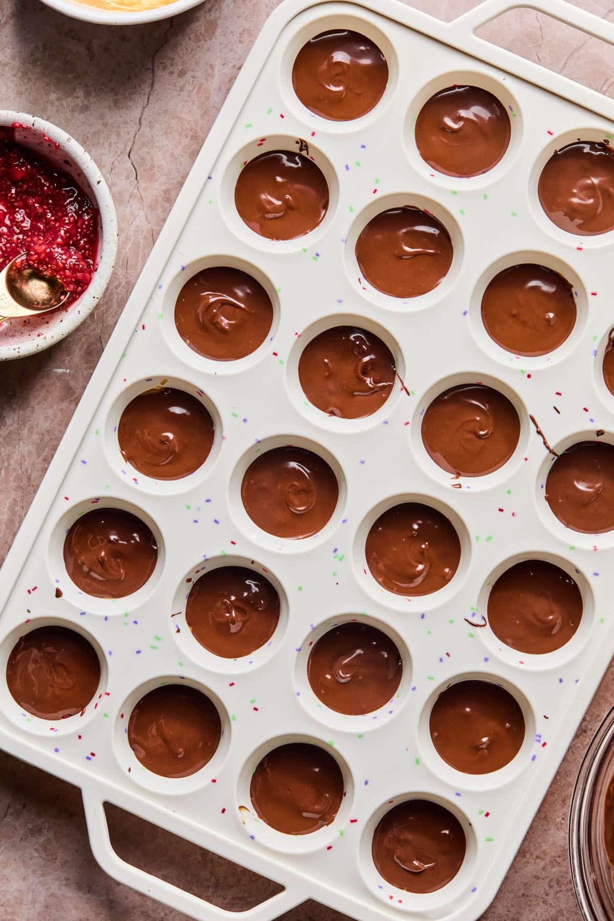 The final chocolate layer on the top of each cup before chilling.