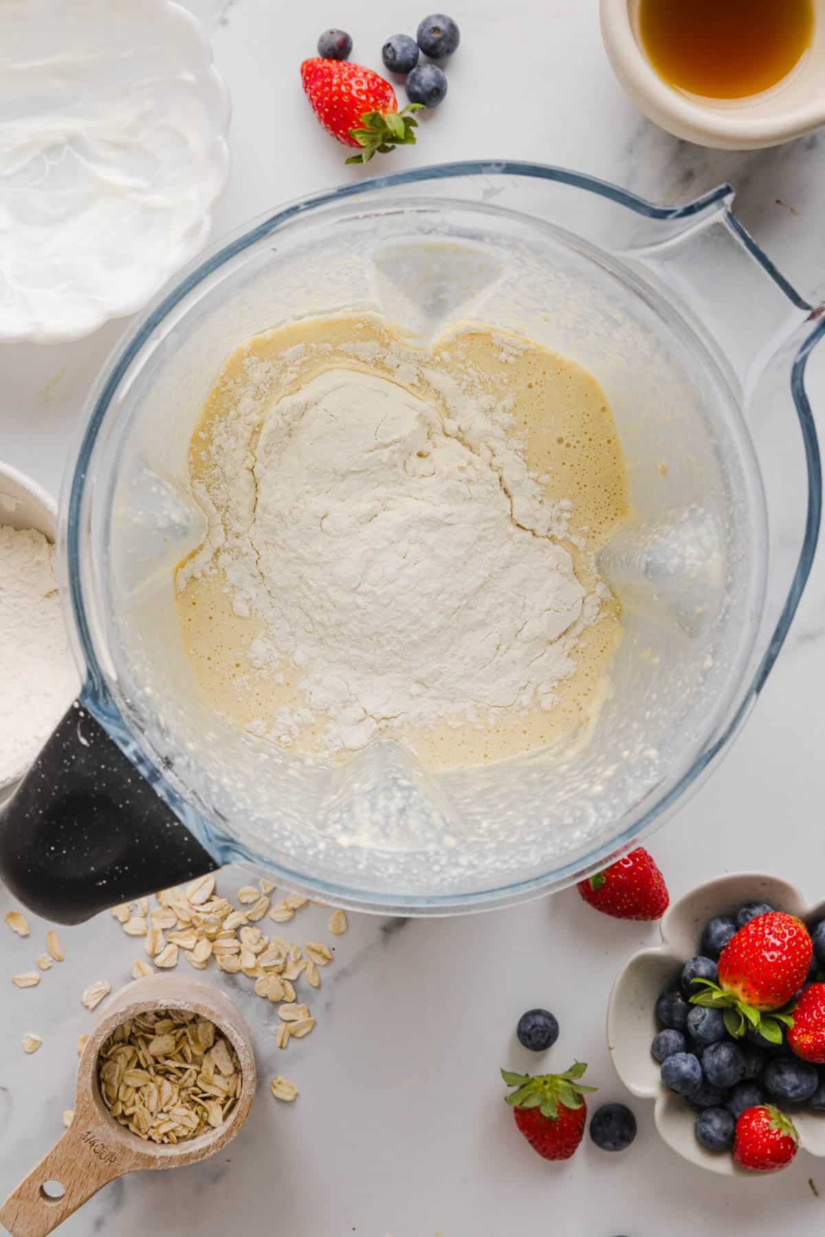 The all purpose flour on top of the mixed waffle batter ingredients for final blend.