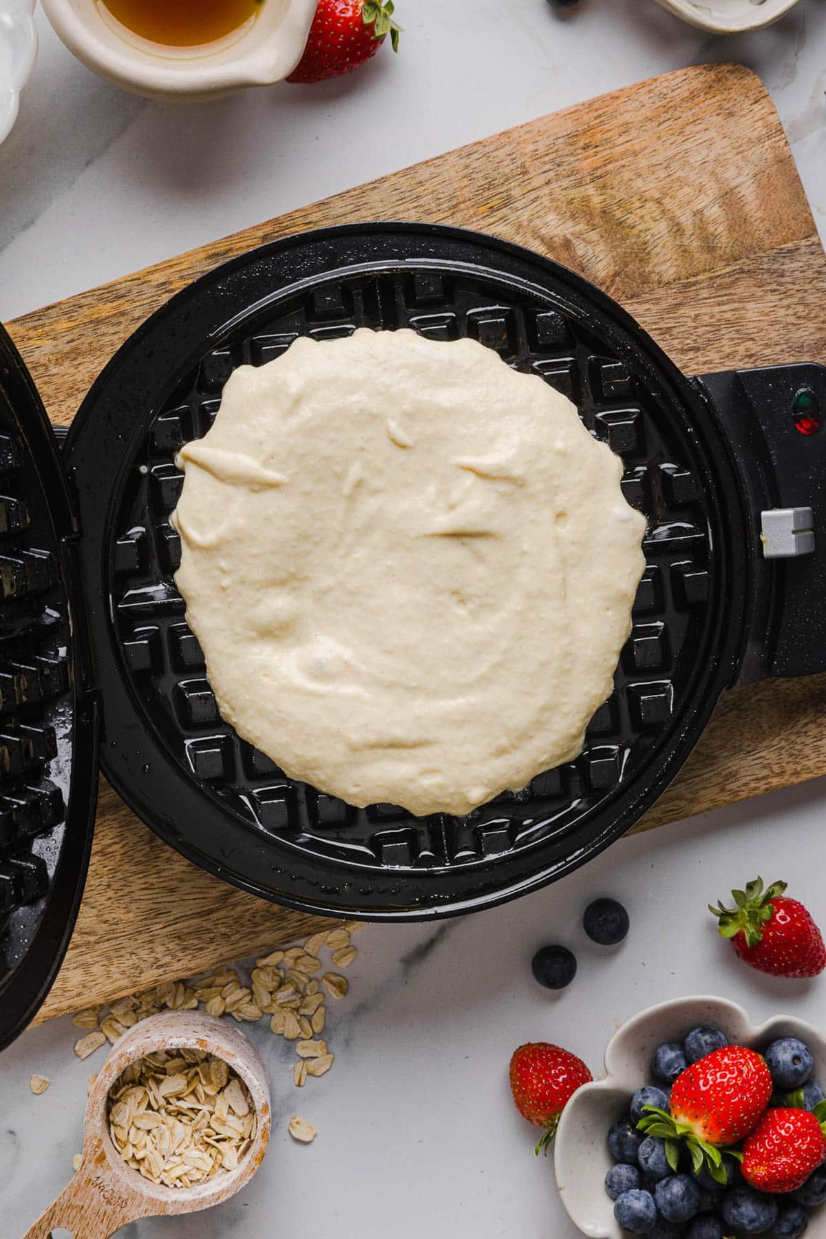The waffle batter in the hot iron before cooking.