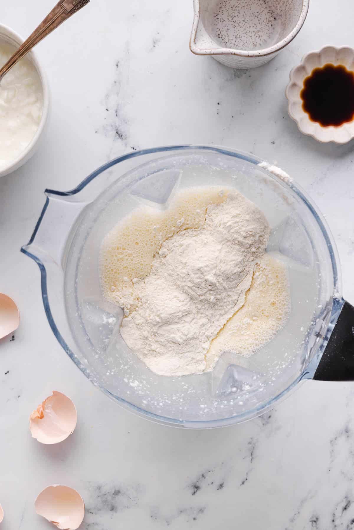 The flour with the blended cottage cheese mixture in the blender.