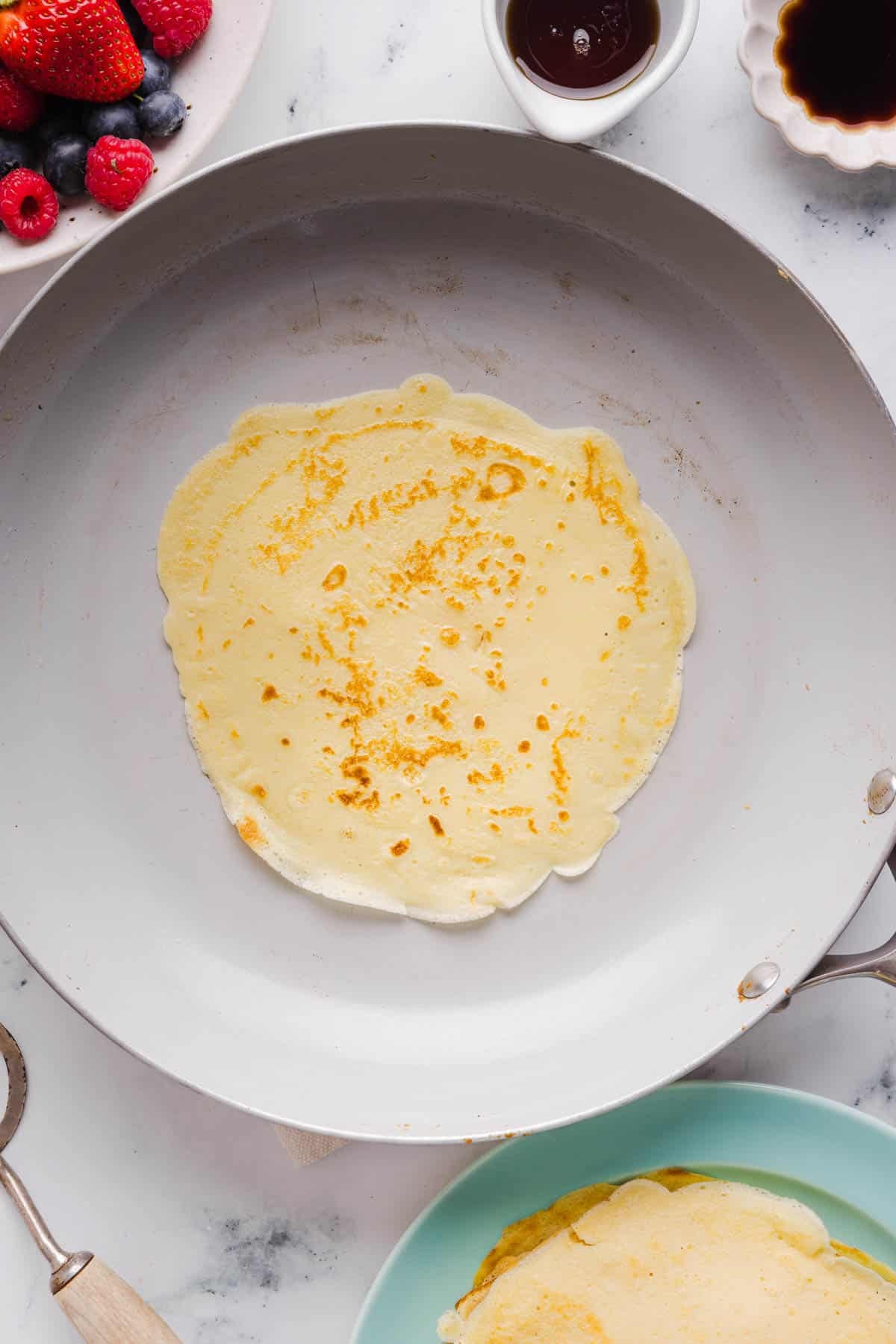 The crepe in the skillet after cooking.