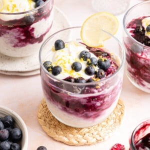 Fresh blueberries on top of lemon blueberry overnight oats in a glass jar with a lemon slice garnished on the rim.