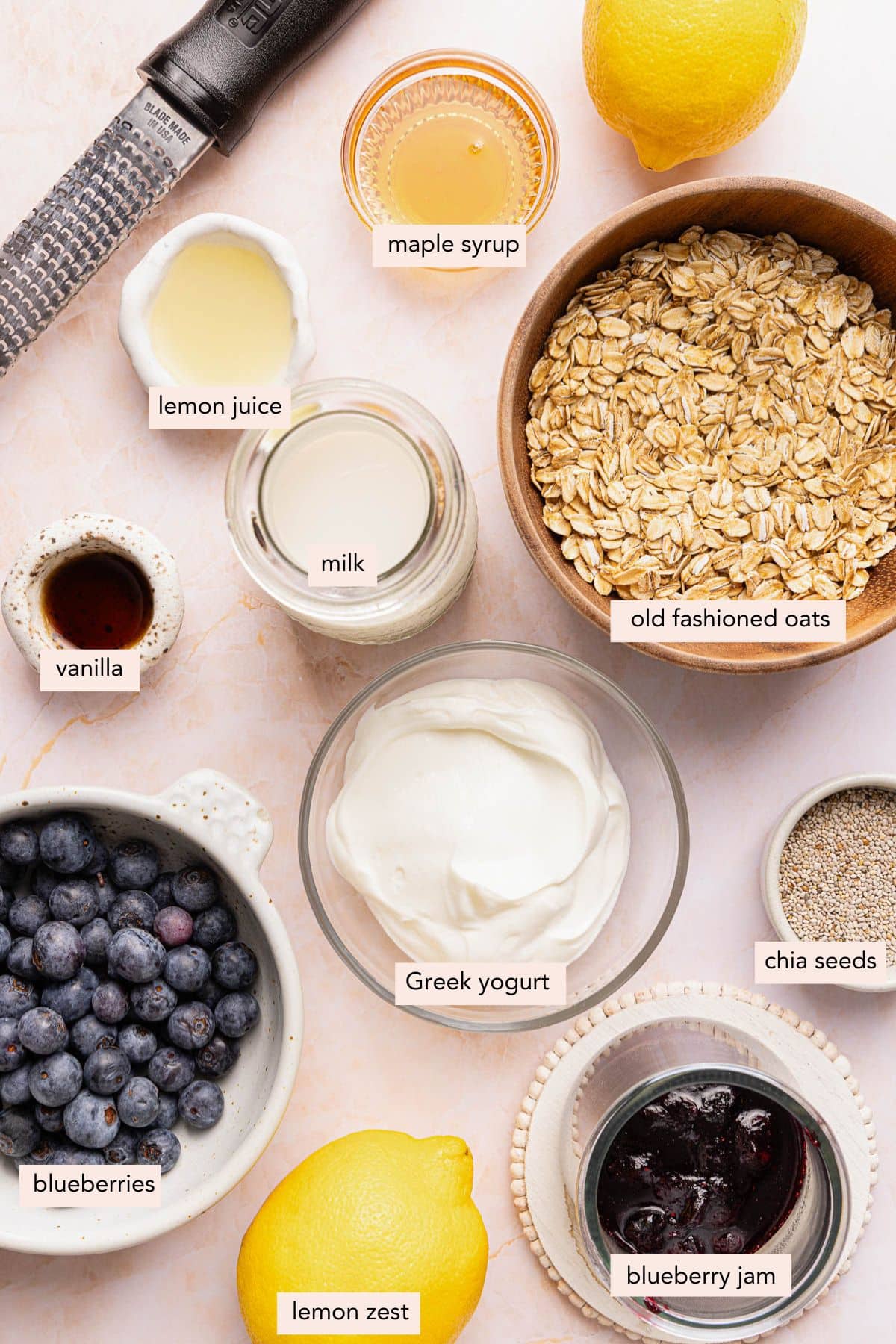 All of the ingredients for lemon blueberry overnight oats in bowls on a countertop.