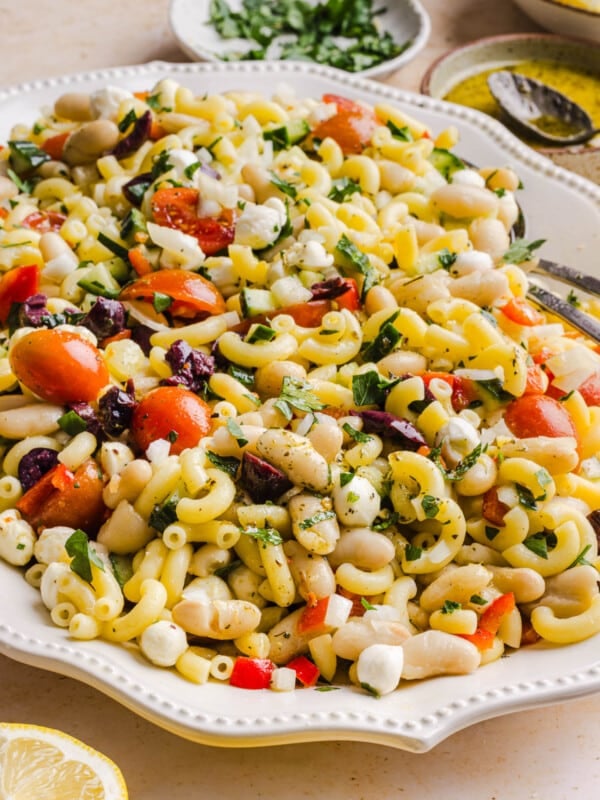 Pasta and bean salad on a white serving platter on a countertop.